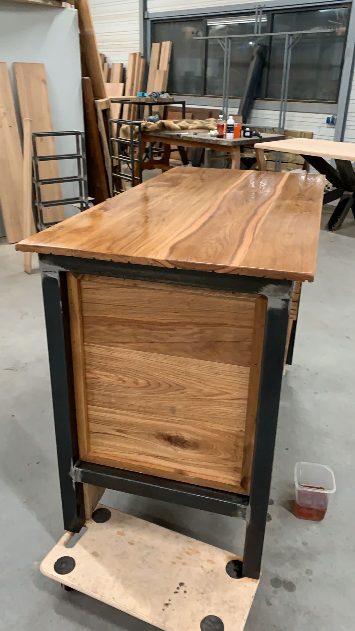 Tafel met een houten blad op een stalen onderstel met zwenkwielen, in de werkplaats