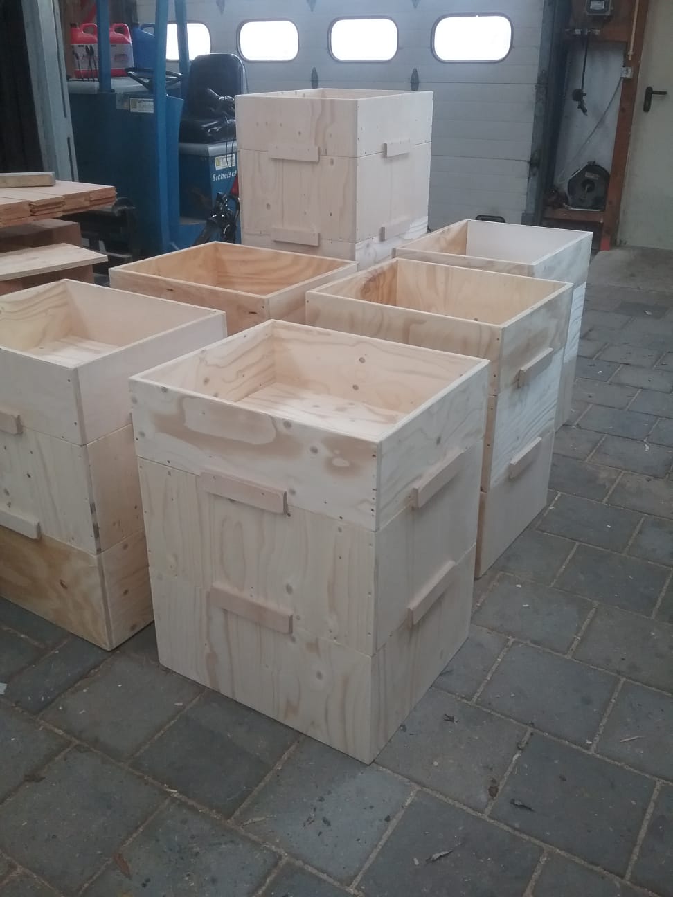 Stapel houten kratten met handgrepen in de werkplaats