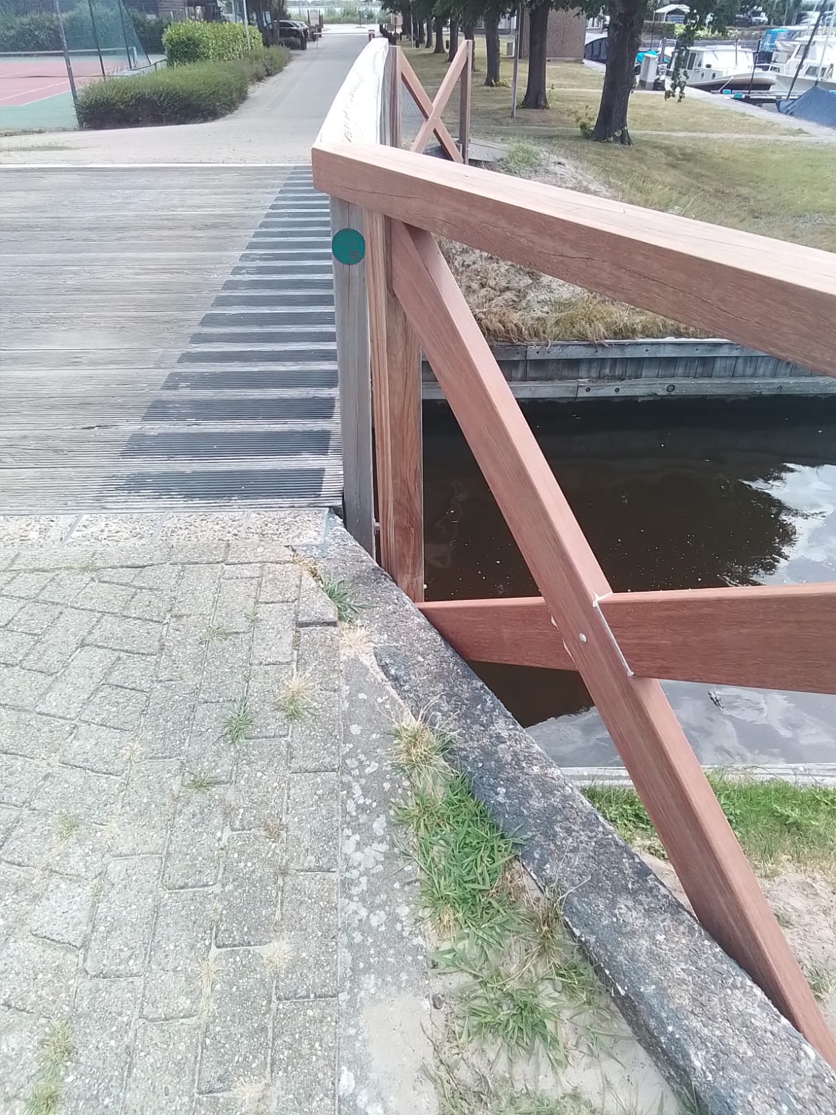 Houten leuning met schoren bij een brug over het water